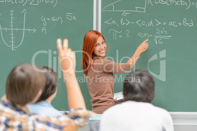 Math student write on green chalkboard classmates