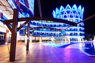 The swimming pool and building of luxury hotel in night illumina