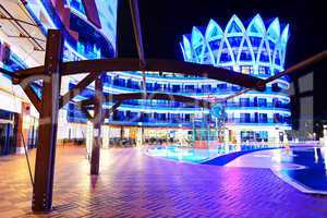 The swimming pool and building of luxury hotel in night illumina