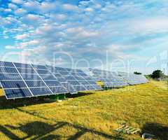 Solar panels on a countryside field with sunny sky