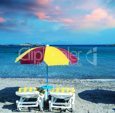 Colourful beach chairs with straw umbrellas on a beautiful sandy