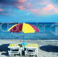 Colourful beach chairs with straw umbrellas on a beautiful sandy