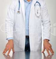 Doctor with hands resting on the table for examination