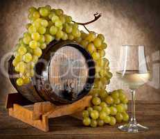 White wine with grapes and barrel