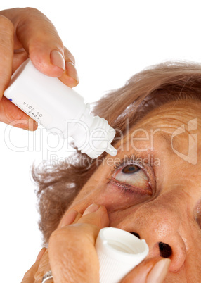 Elderly woman applying eye drops