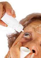 Elderly woman applying eye drops