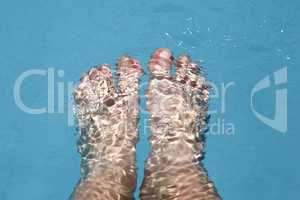 Splashing female feet in a swimming pool
