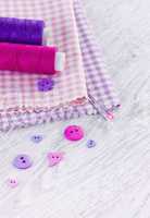 Sewing items with a check fabrics, buttons, thread and pins