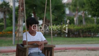 Unhappy lonely  child swinging