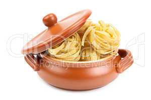 Spaghetti in a clay pot isolated on white background