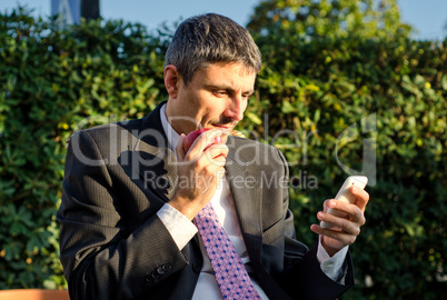 Business Man Outdoor Consulting his Smartphone