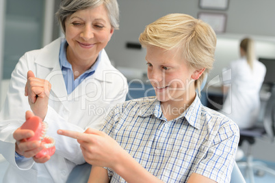 Teenage patient boy dentist woman show dentures