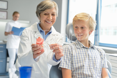 Dentist show teenage patient teeth dentures nurse