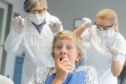 Scared teenage patient frighten dentist and nurse
