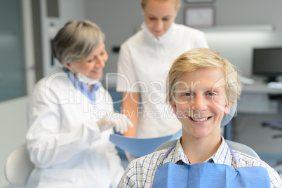 Teenage patient, dentist woman with dental assistant