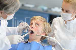 Dentist and assistant with scared teenage patient