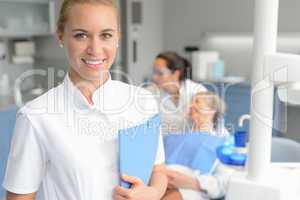 Dental assistant smiling dentist with patient