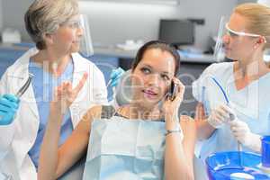 Busy businesswoman at dental surgery on phone