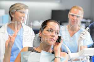 Impolite businesswoman on phone in dental office