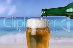 Bier eingießen aus Flasche ins Glas am Strand