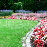 bright flower bed and green grass in the summer park