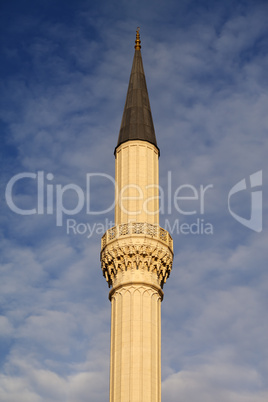 Minaret of mosque against sky with clouds