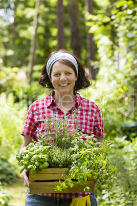 Junge Frau mit Kräutern im Garten, young woman with herbs in a garden