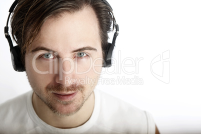 Attractive man with headphones looks into the camera