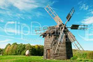 Old wooden windmill in the background of the autumn forest