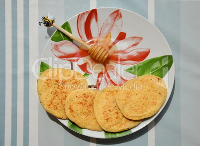 Plate with pancakes and honey