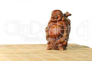 Statuette of laughing Buddha on a white background