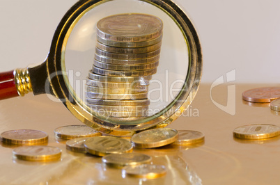 A stack of coins under a magnifying glass