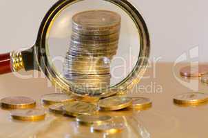 A stack of coins under a magnifying glass