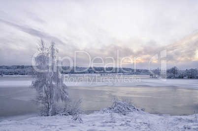 Winter landscape with lake and trees covered with frost