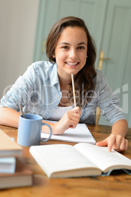 Student teenage girl studying at home smiling