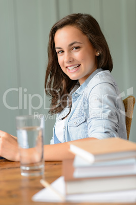 Smiling teenage girl student at home