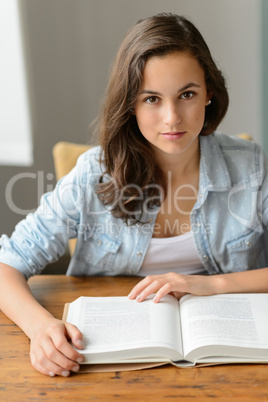 Student teenage girl reading book looking camera