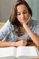 Student teenage girl reading book at home