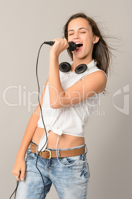 Singing teenage girl with microphone closed eyes