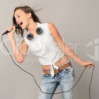 Singing teenage girl with microphone karaoke music