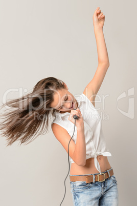 Dancing teenage girl singing with microphone