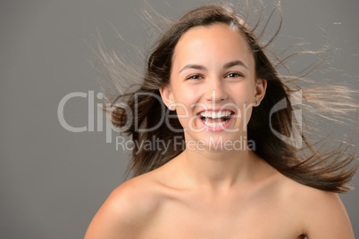 Laughing teenage girl blowing hair beauty skin