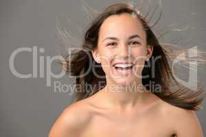 Laughing teenage girl blowing hair beauty skin