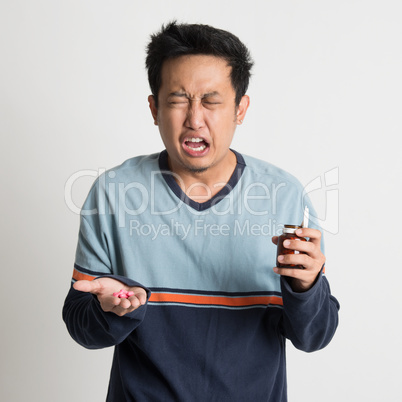 Man holding medicine bottle while sneezing