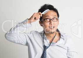 Asian businessman combing hair