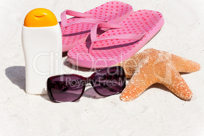 Sonnenmilch und Flip-Flops am Strand