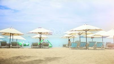 Sun umbrellas and chairs on a sandy beach.