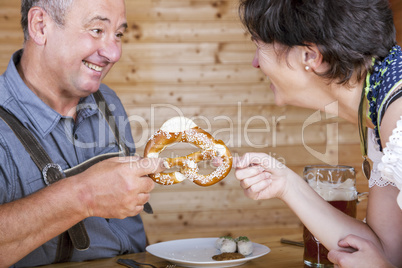 Man and woman with pretzel, beer and white sausage