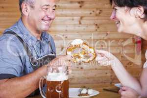 Man and woman with pretzel, beer and white sausage