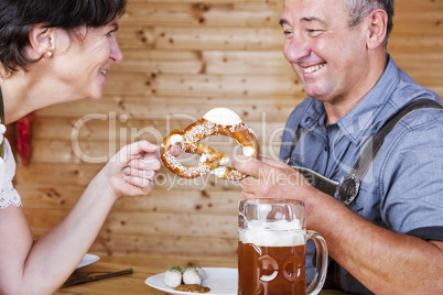 Man and woman with pretzel, beer and white sausage